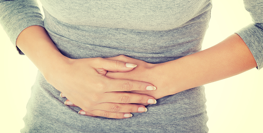 woman holding her hands over her stomach 