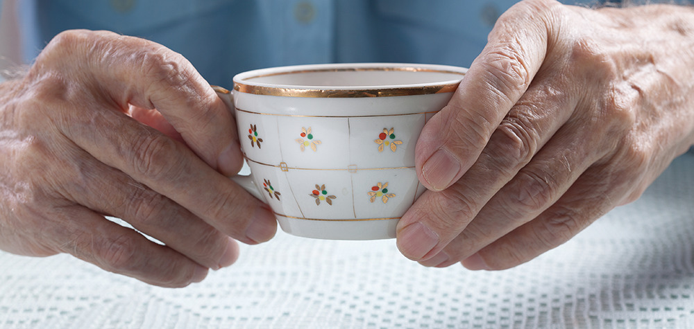 elderly hands holding tea cup