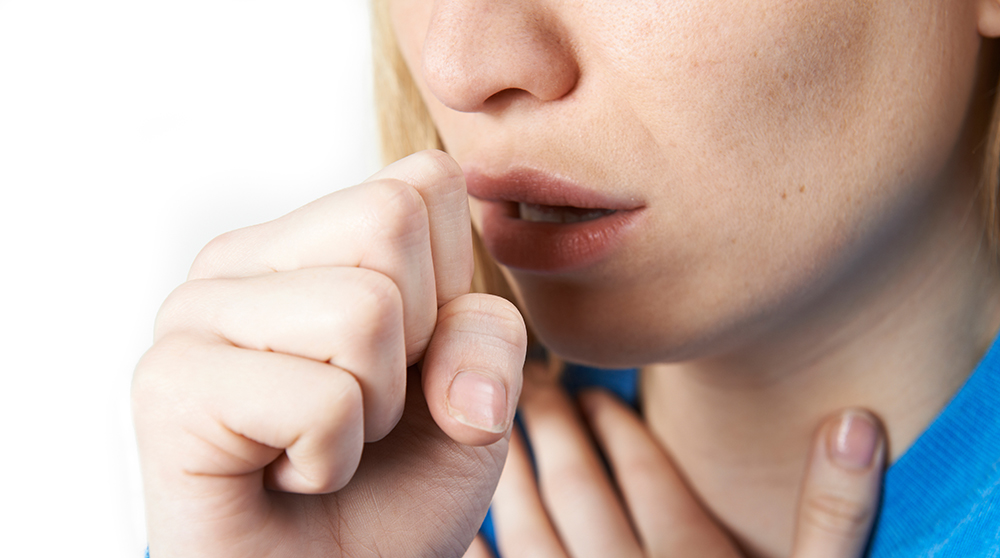 Woman coughing into her hand