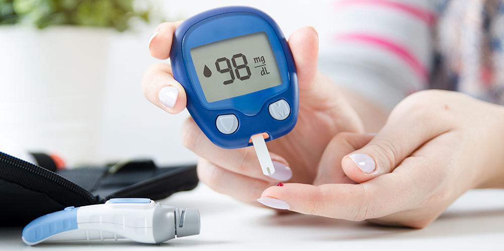 Hands on tabletop using glucose meter 